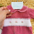 Dettaglio del colletto e del ricamo a mano rose sulla tutina neonata rosa