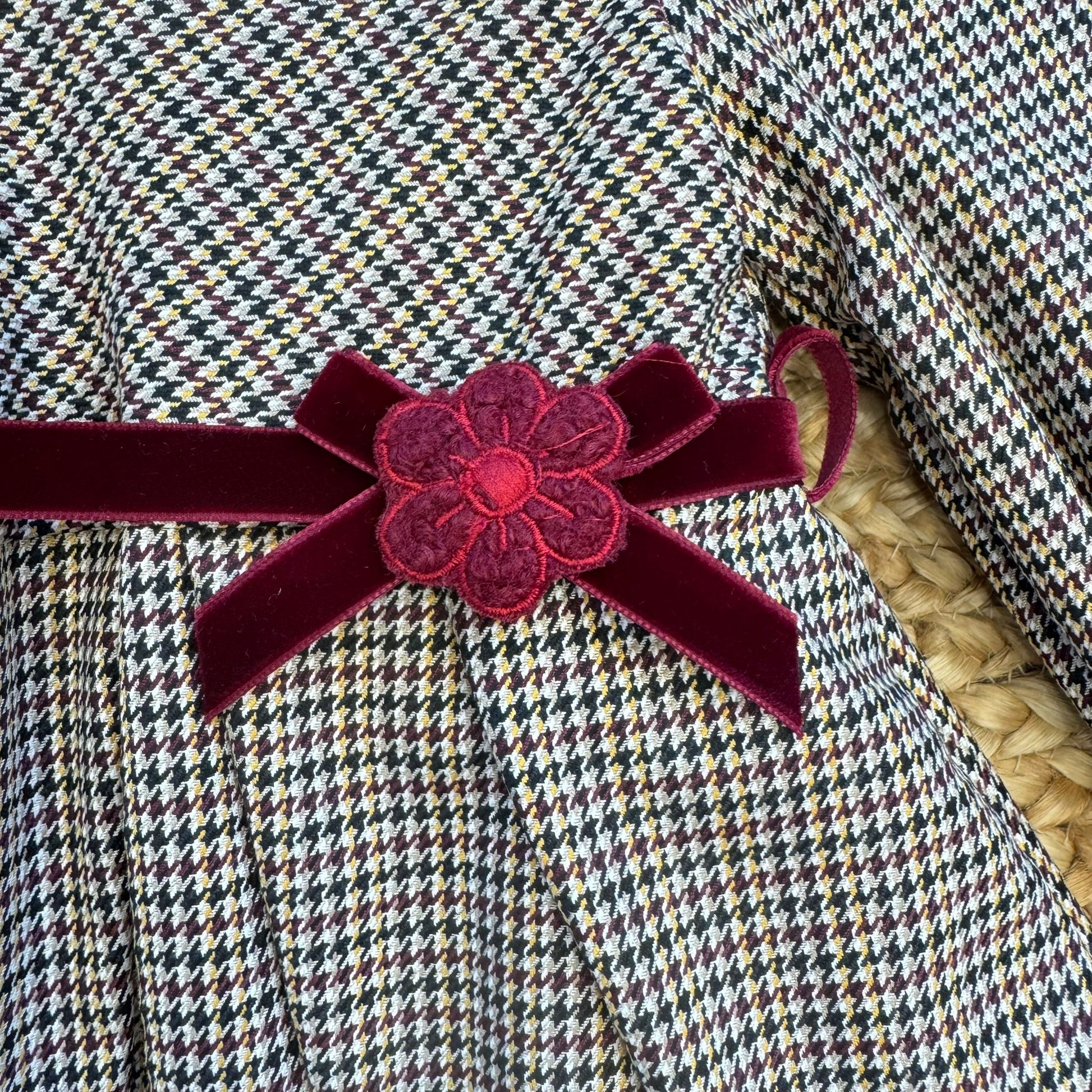 Dettaglio fiocco velluto bordeaux con fiore ricamato abito bambina