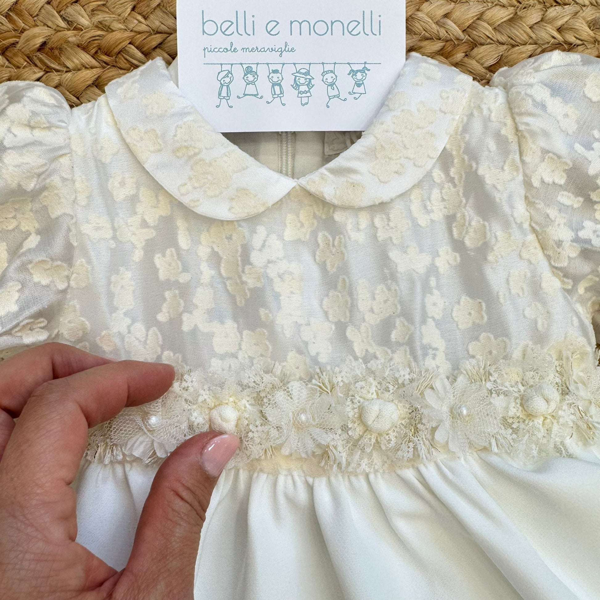 Dettaglio fiori e perline su abito battesimo neonata avorio