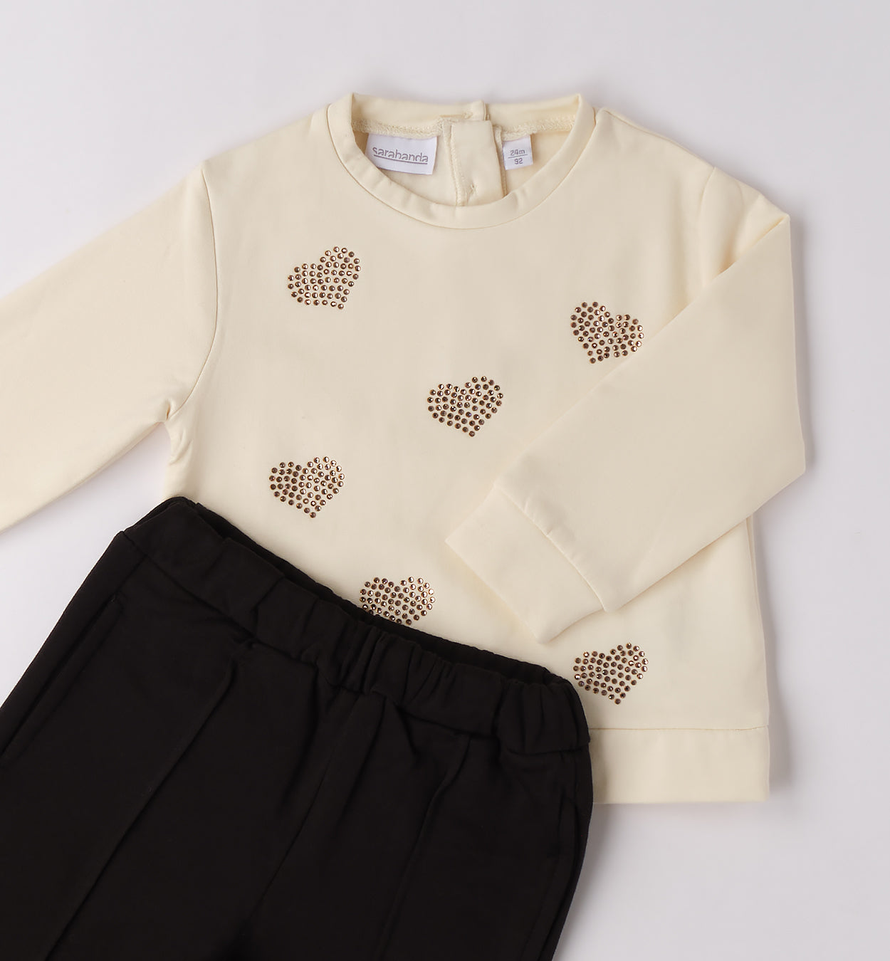 Dettaglio maglia panna con cuori strass dorati per bambina