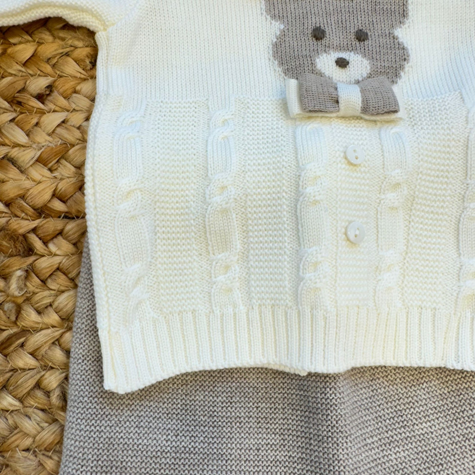 Dettaglio maglia tutina due pezzi con lavorazione trecce e orsetto