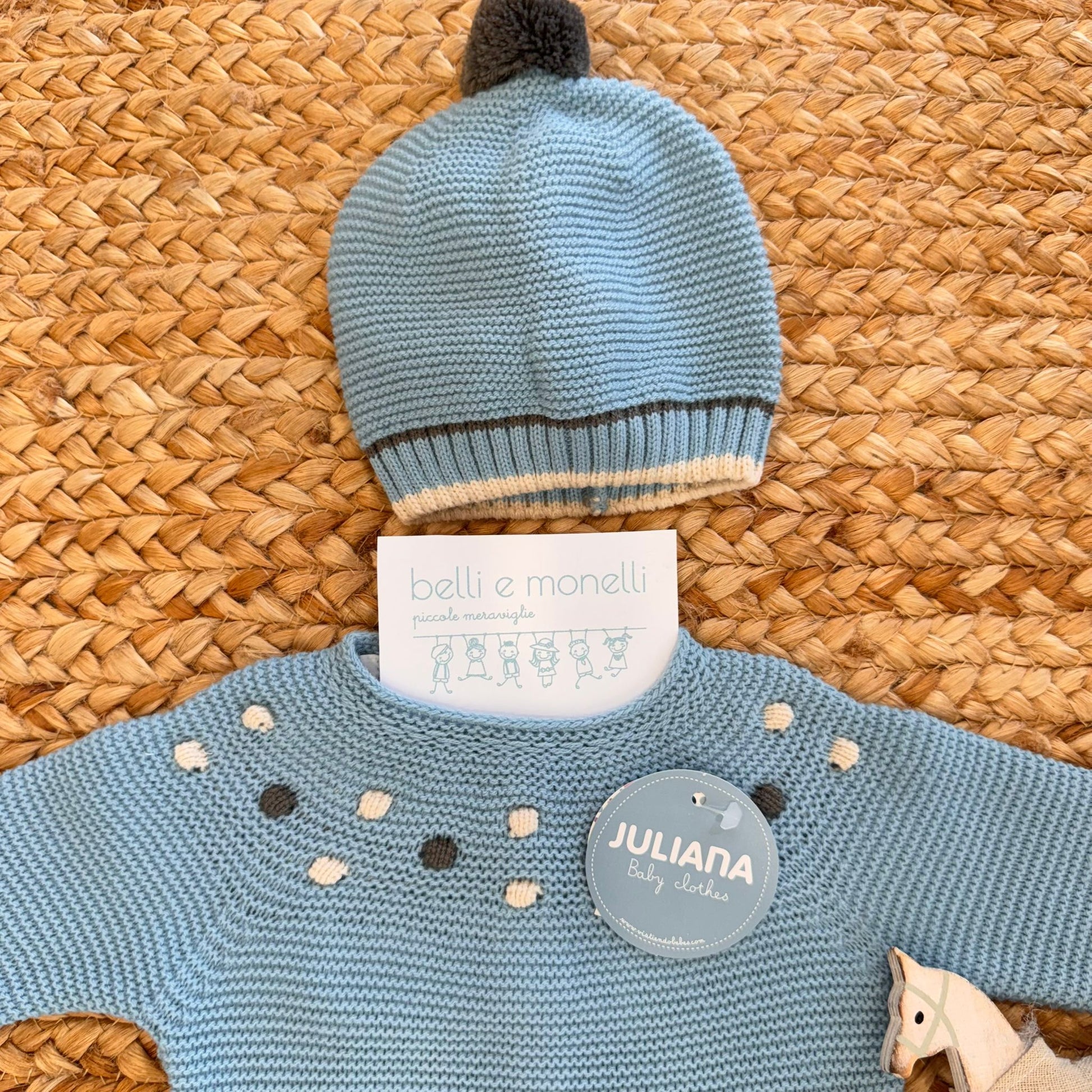 "Dettaglio manica e scarpine abbinate in maglia azzurra con pois bianchi e grigi"