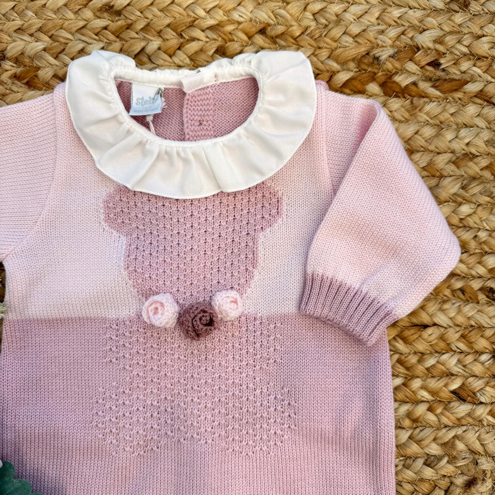 Dettaglio orsetto ricamato su tutina neonata in pura lana rosa con fiori crochet