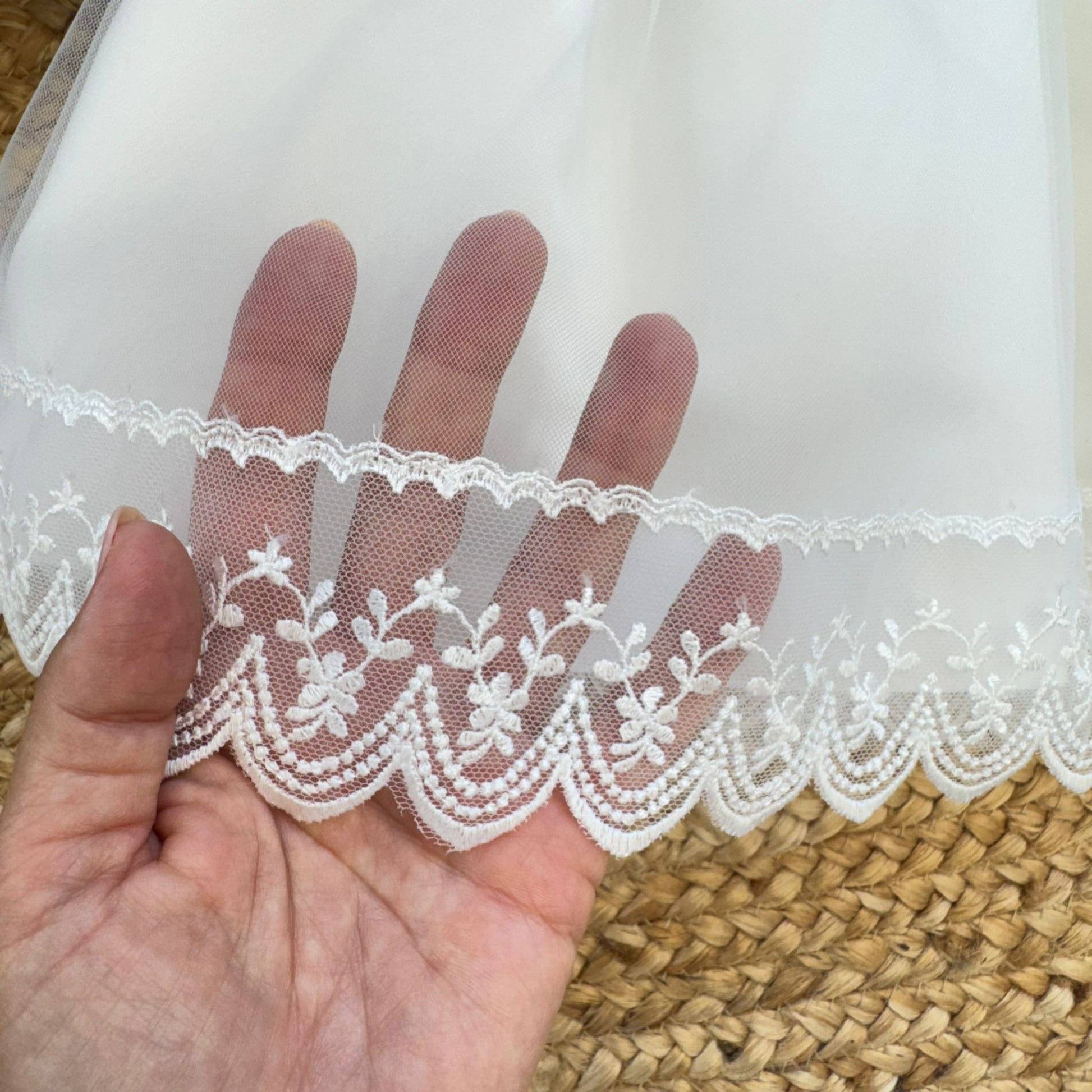 Dettaglio pizzo ricamato abito battesimo bimba