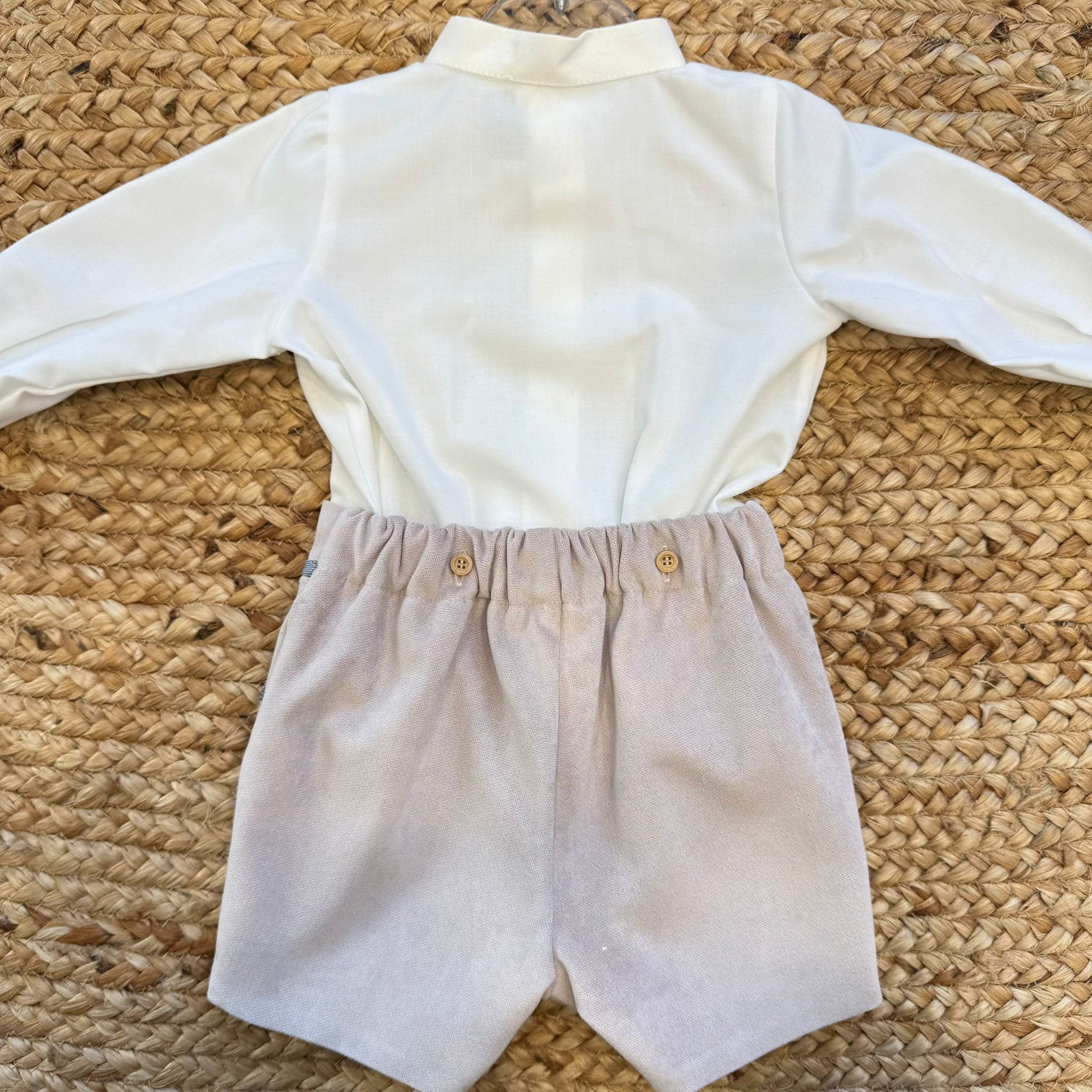 Dettaglio polsino camicia panna con profilo blu