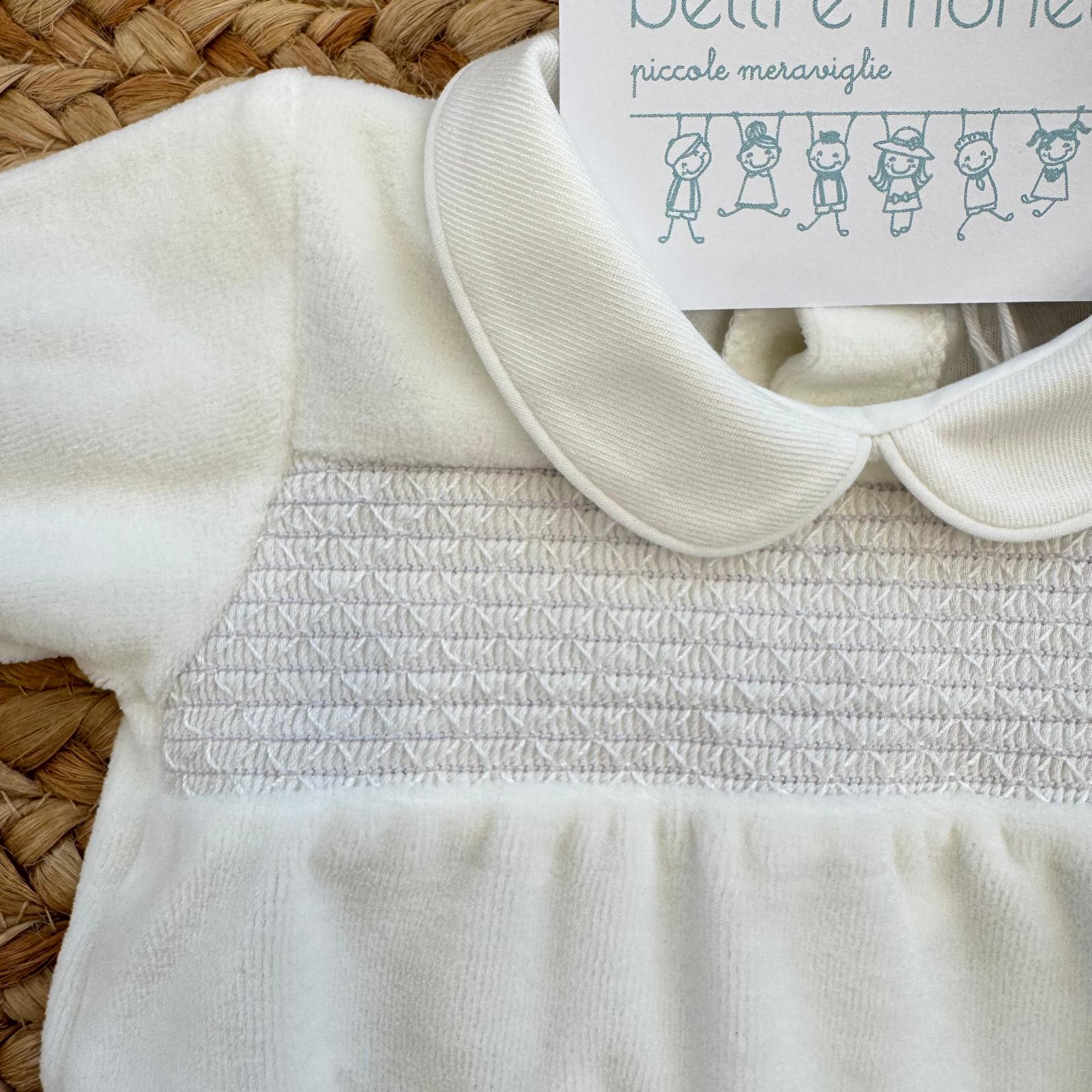 Dettaglio ricamo a nido d’ape della tutina in ciniglia bianca elegante.