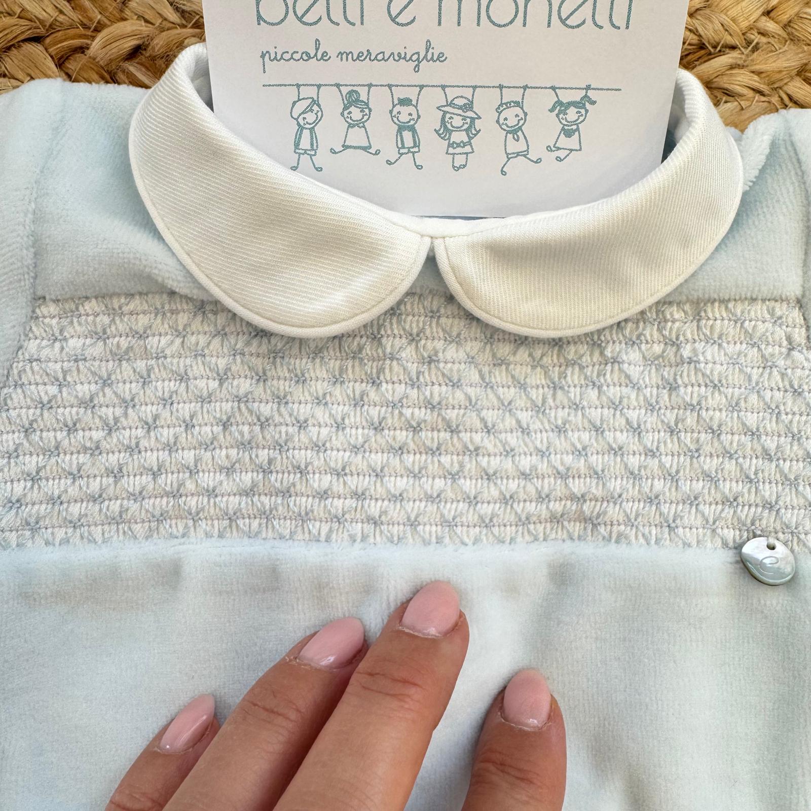 Dettaglio ricamo a nido d’ape sulla tutina neonato azzurra