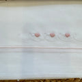 Dettaglio ricamo cuori rosa sul lenzuolo neonata