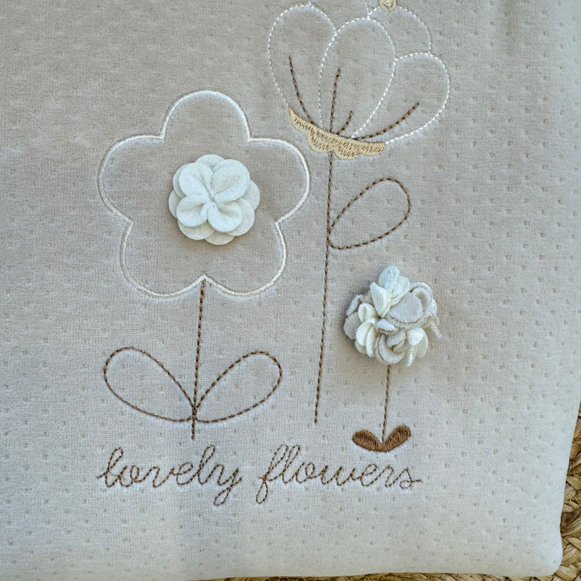 Dettaglio ricamo fiori tridimensionali copertina neonata