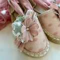 Dettaglio scarpe cerimonia bambina con pizzo e fiore decorativo