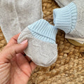 Dettaglio scarpette coordinate azzurre e grigie in lana e acrilico per neonato