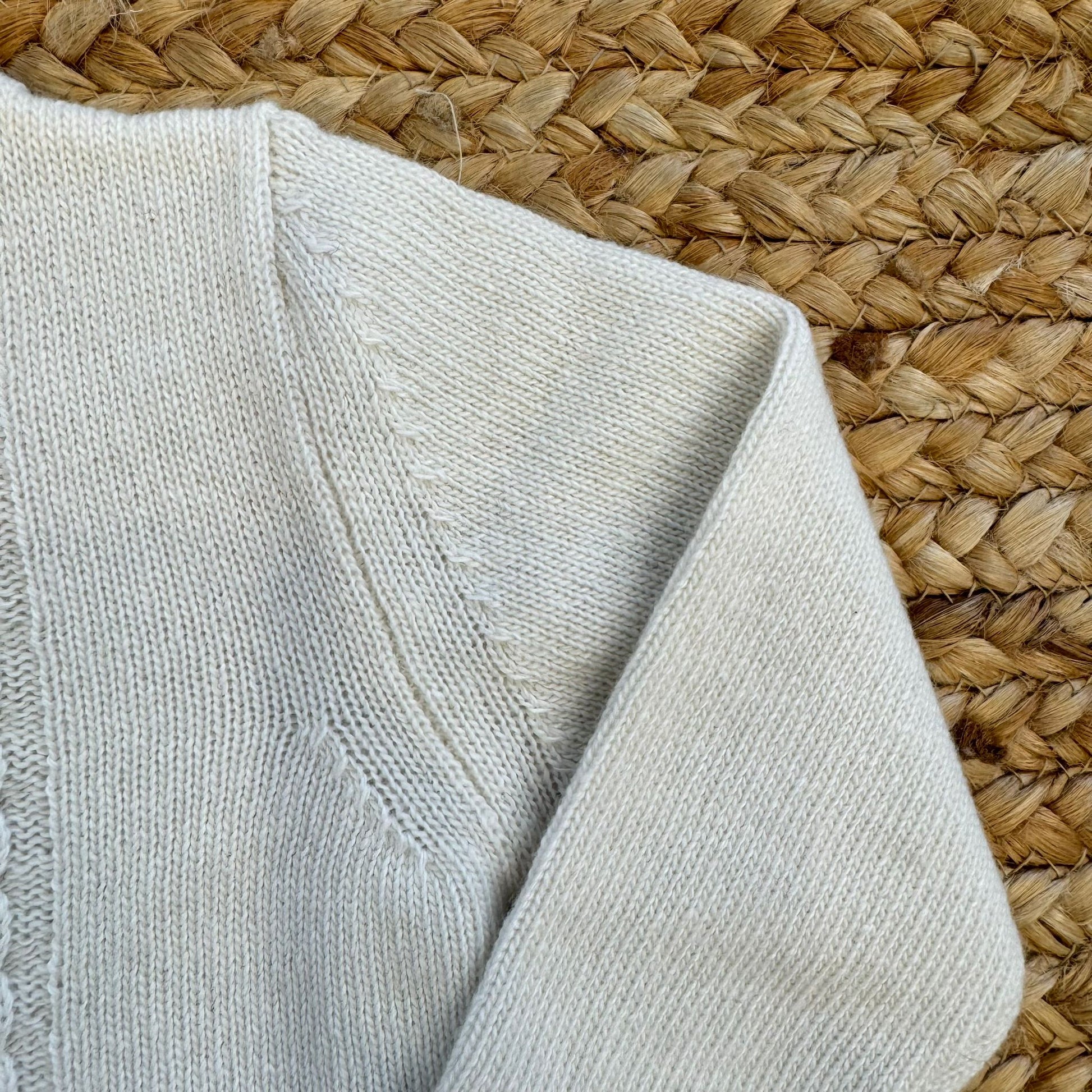 Dettaglio spalla cardigan neonato in maglia