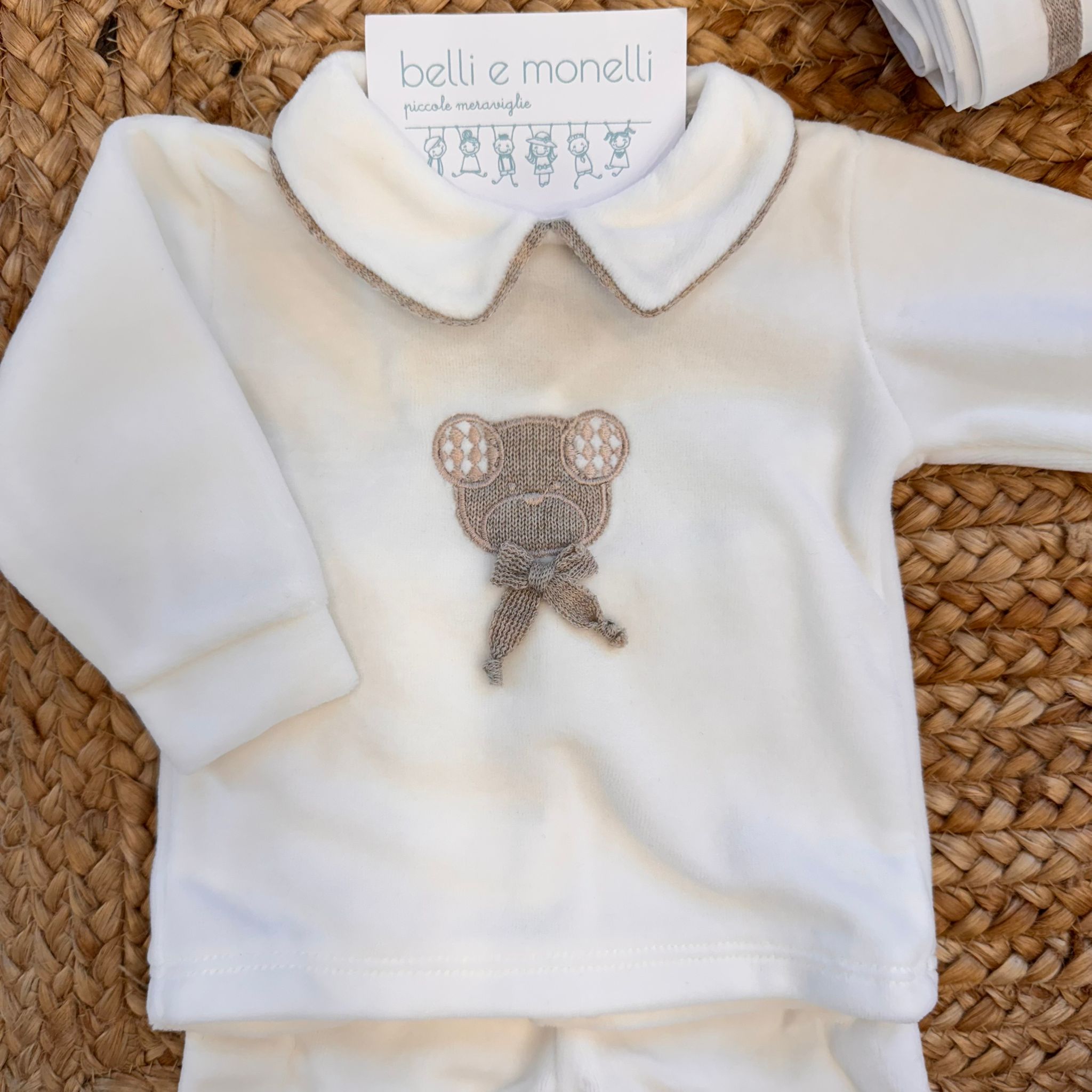 Dettaglio tutina neonato in ciniglia con ricamo orsetto beige