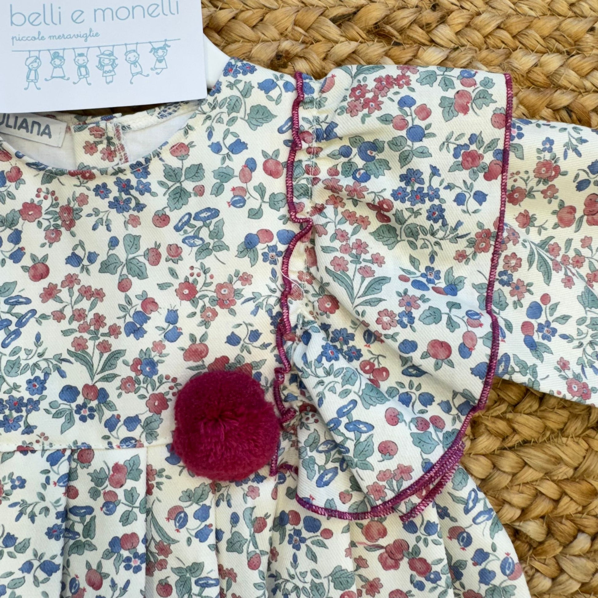 Dettaglio volant rifiniti bordeaux e pompon abito bimba