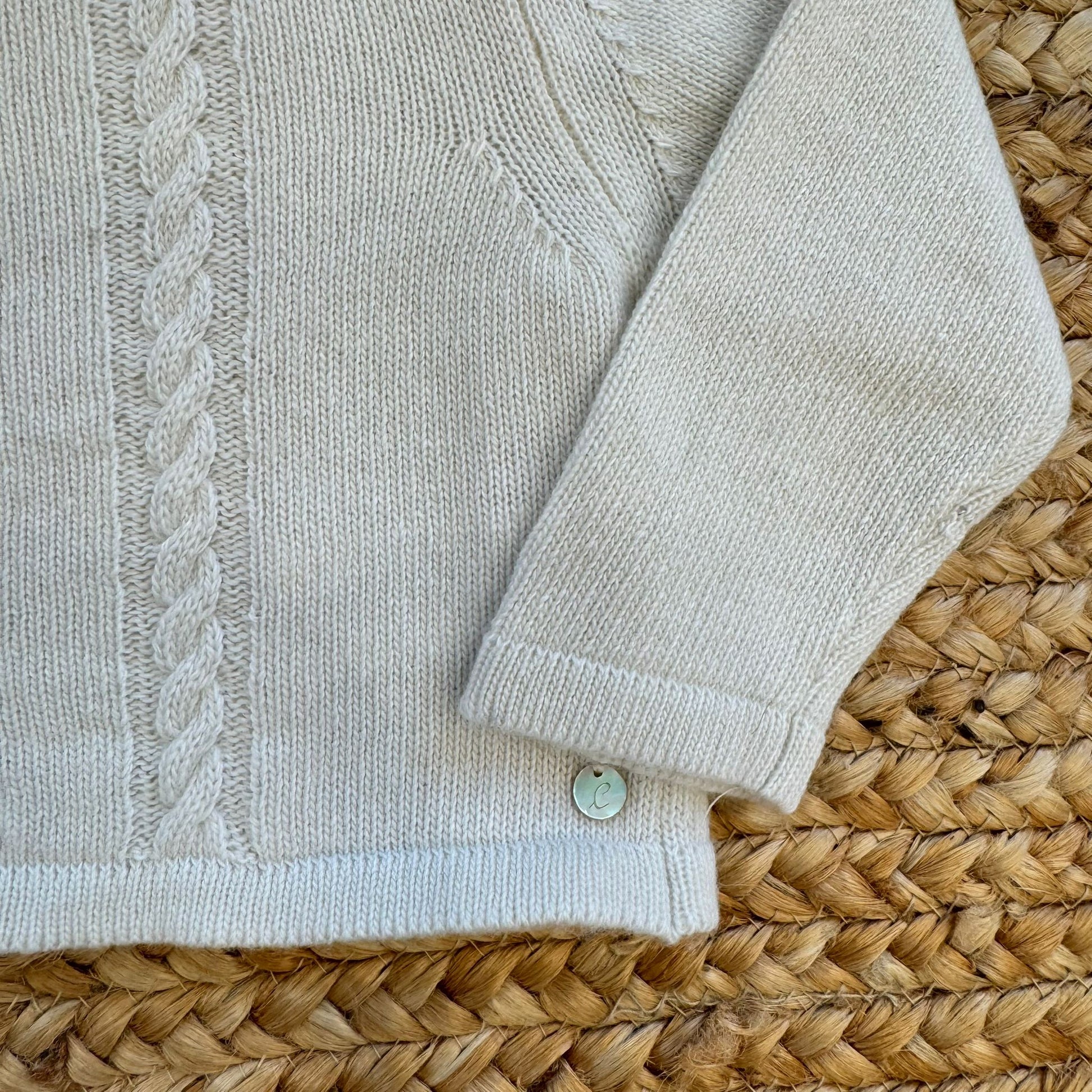 Manica e bordo del cardigan panna lavorato a maglia fine