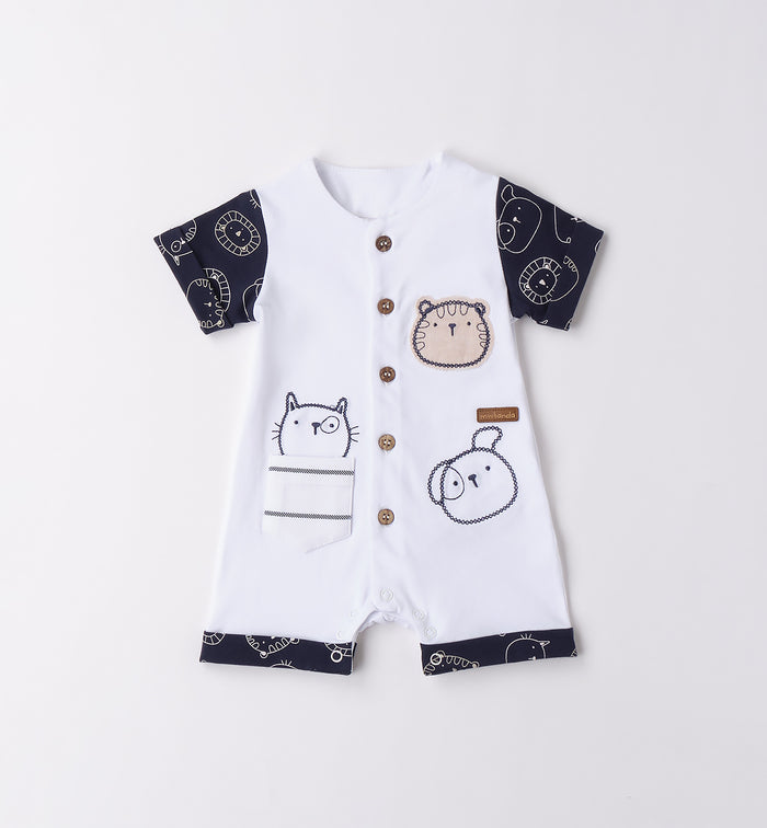 Pagliaccetto neonato bianco con dettagli blu navy, bottoncini in legno e illustrazioni di animaletti. Tessuto leggero e confortevole per l’estate.