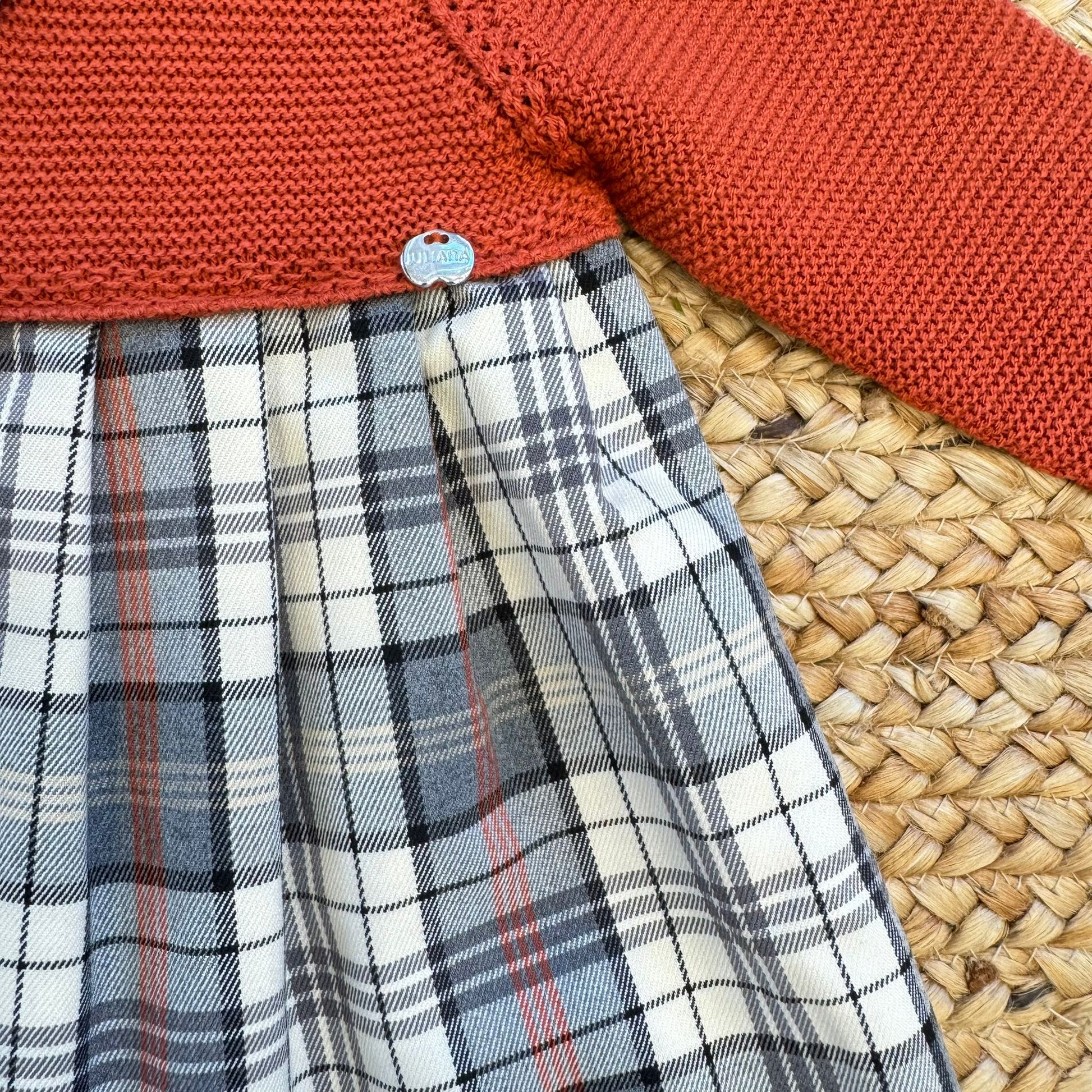 Particolare corpetto in maglia ruggine del vestito neonata