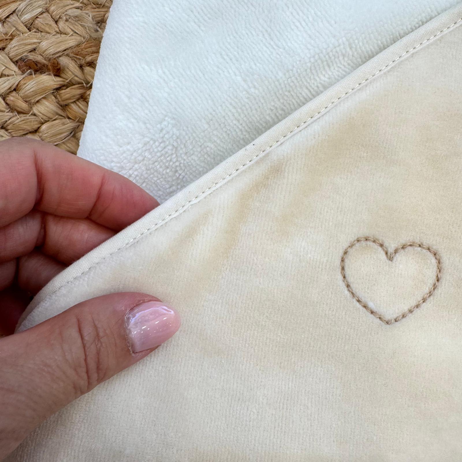 Particolare dei tre cuori rosa ricamati sul cappuccio dell’accappatoio bambù per neonata.