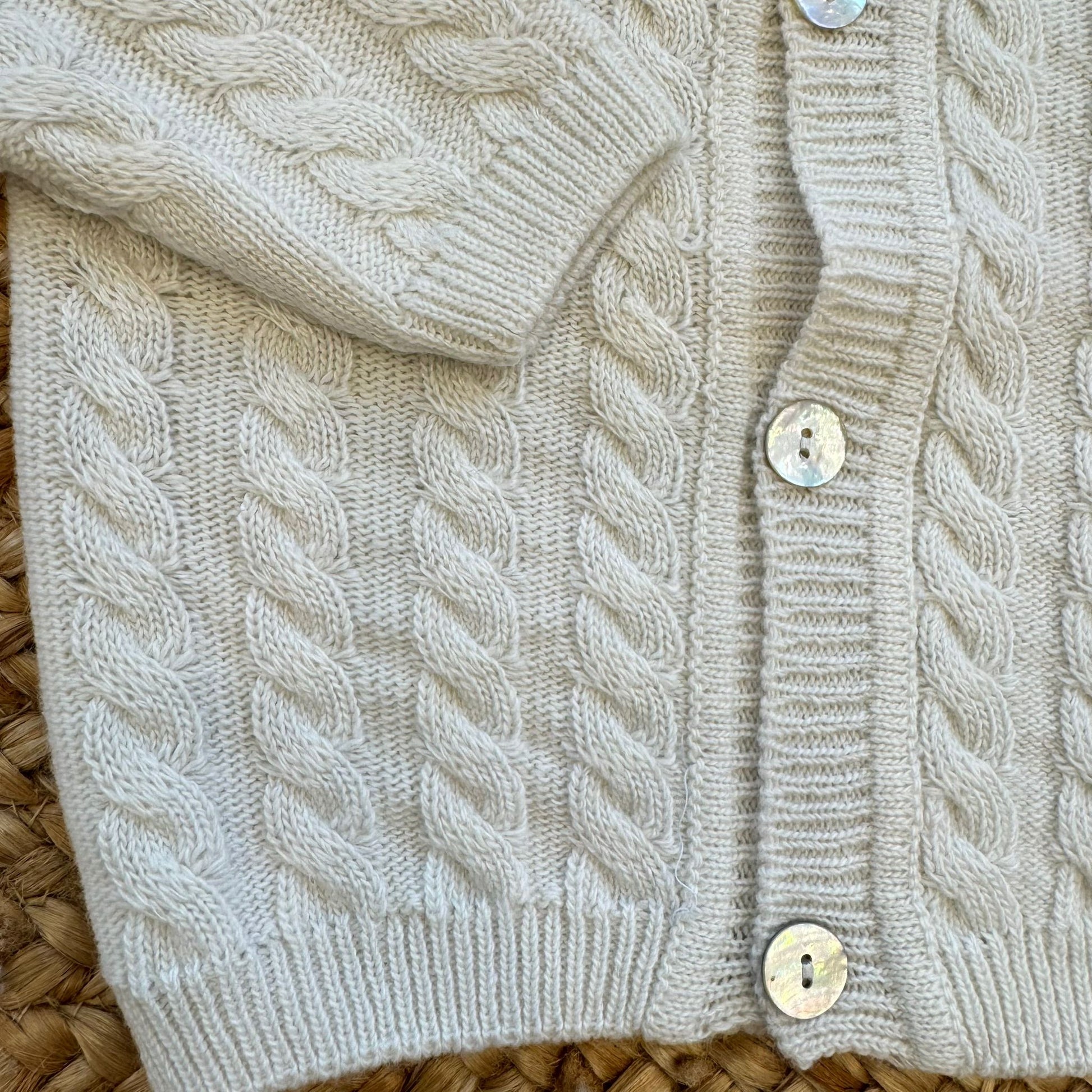 Particolare lavorazione a trecce del cardigan neonato