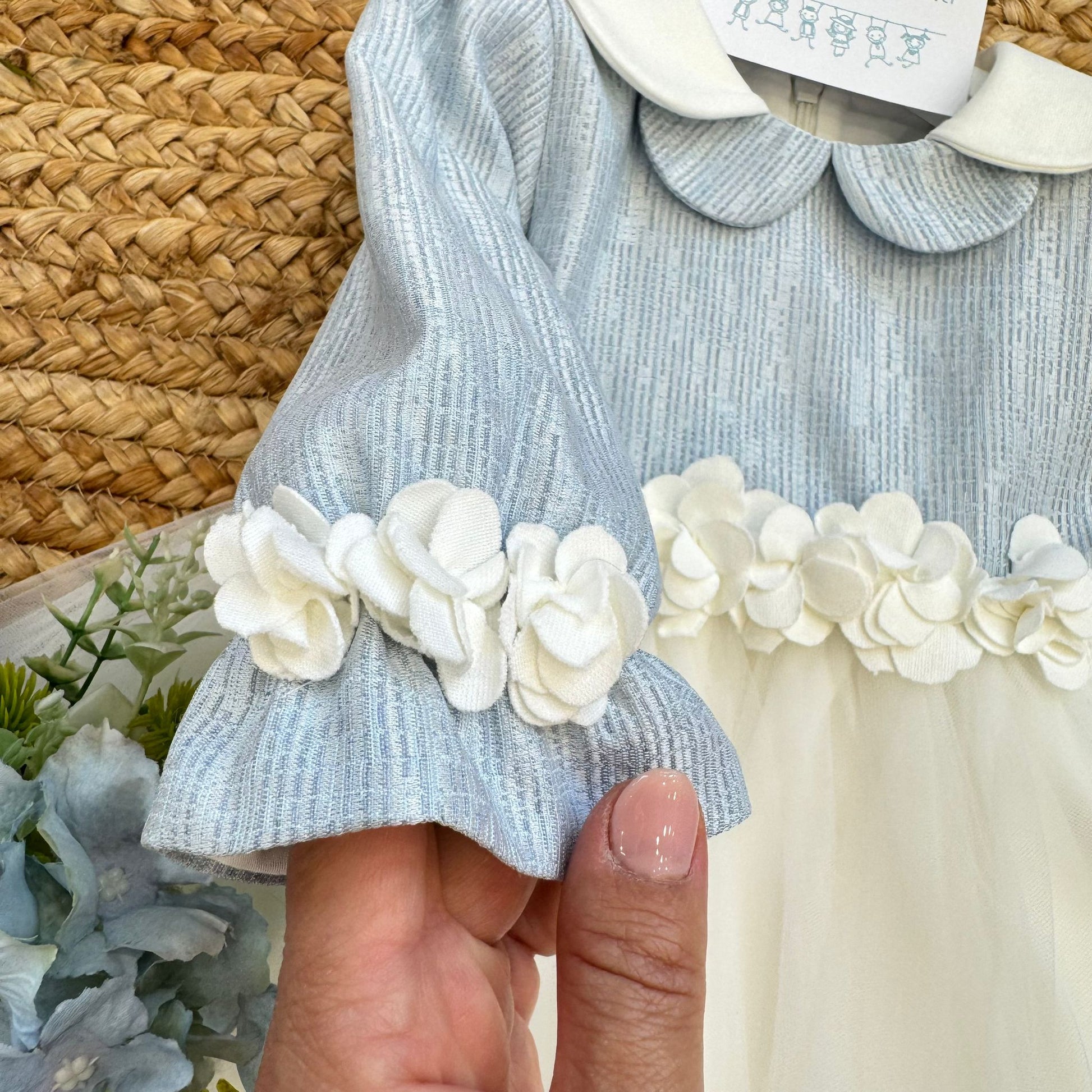 Particolare manica con polsino e applicazione floreale 3D