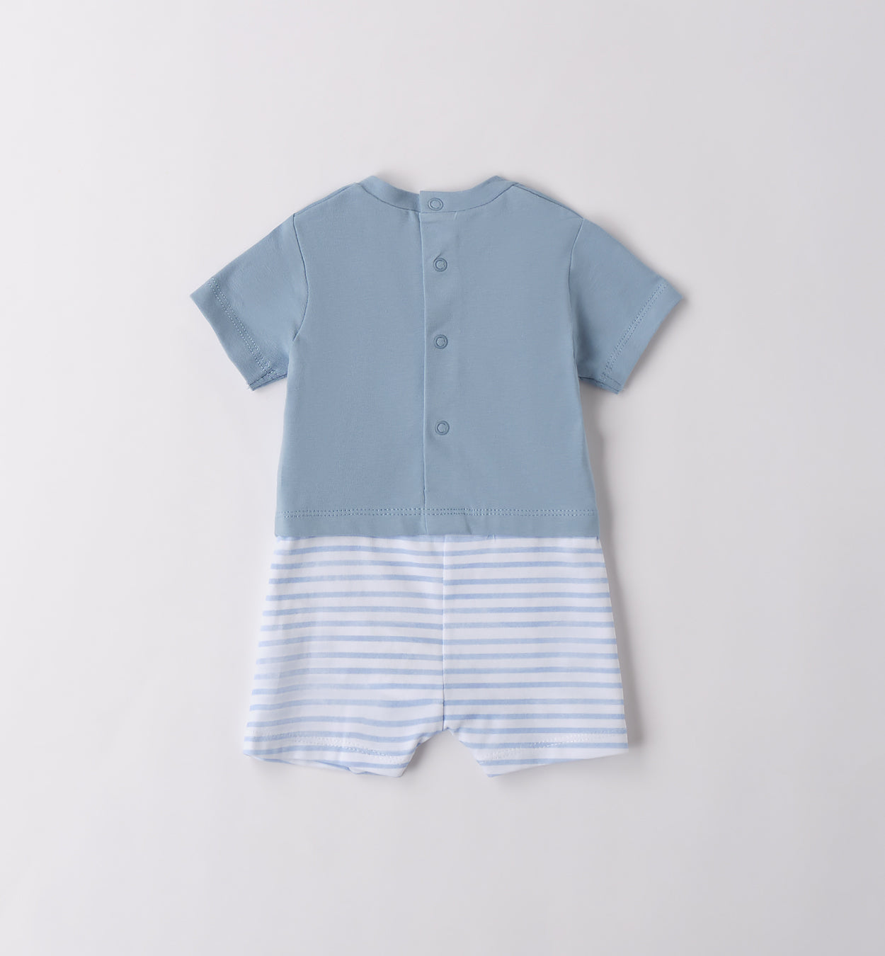 Vista posteriore della tutina corta neonato in cotone azzurro e bianco, con chiusura a bottoni per un cambio pratico. Perfetta per l’uscita clinica e l’estate.