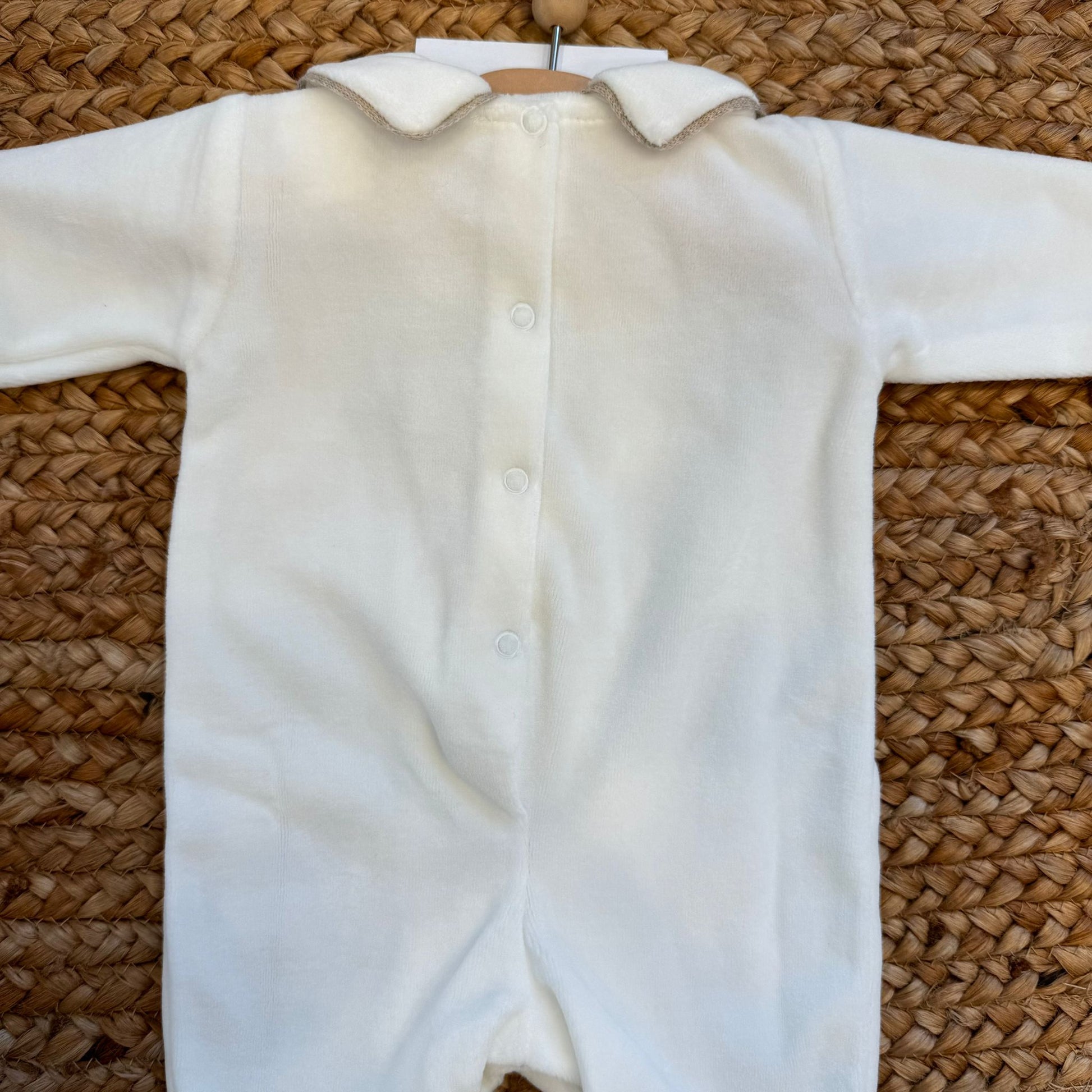 Retro della tutina in ciniglia panna per neonato con bottoncini a pressione.