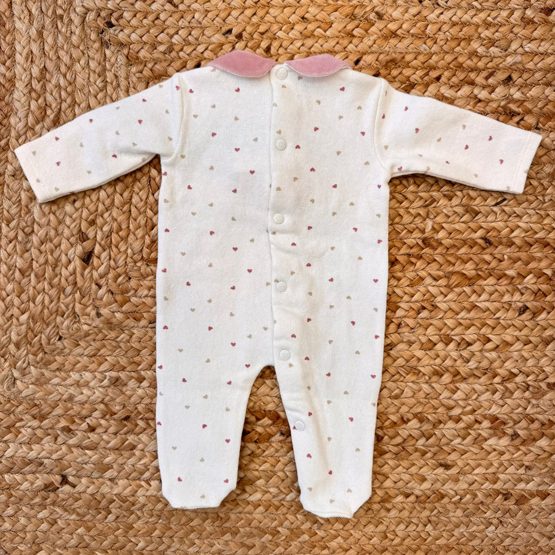 Tutina per neonata in caldo cotone bianco e ciniglia rosa con cuori sul davanti.