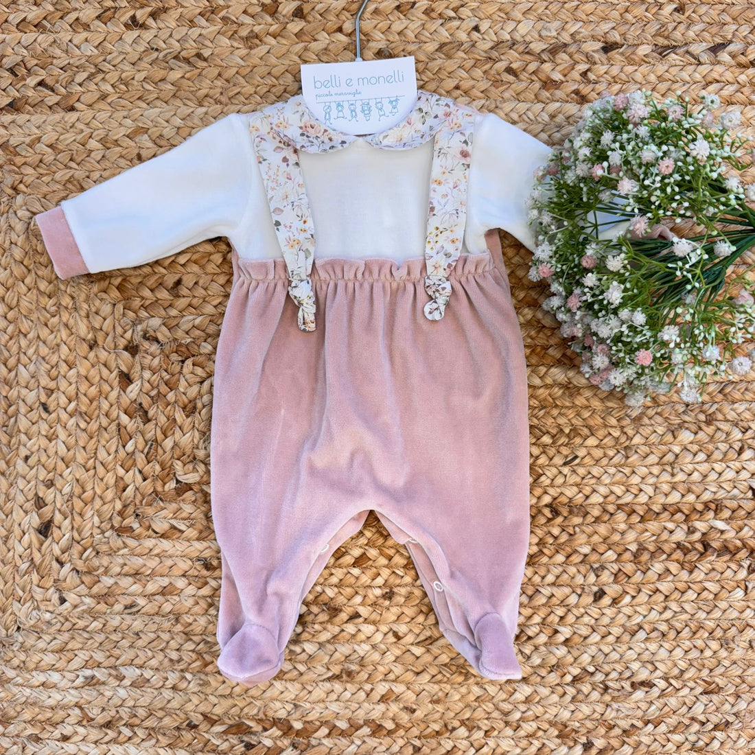 Tutina in ciniglia rosa cipria con colletto e bretelle floreali per neonata.