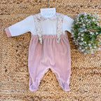 Tutina in ciniglia rosa cipria con colletto e bretelle floreali per neonata.