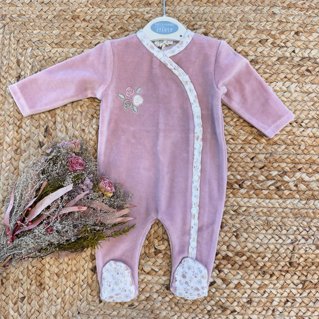 Tutina neonata in ciniglia rosa con ricami floreali e dettagli fantasia.