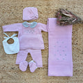 Uscita clinica neonata in lana e acrilico rosa con colletto grigio e ricami, completa di copertina, cappellino, bavetta e scarpine