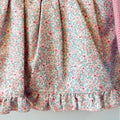 Abitino bimba rosa con culotte coordinata, corpetto in maglia e gonna floreale elegante.