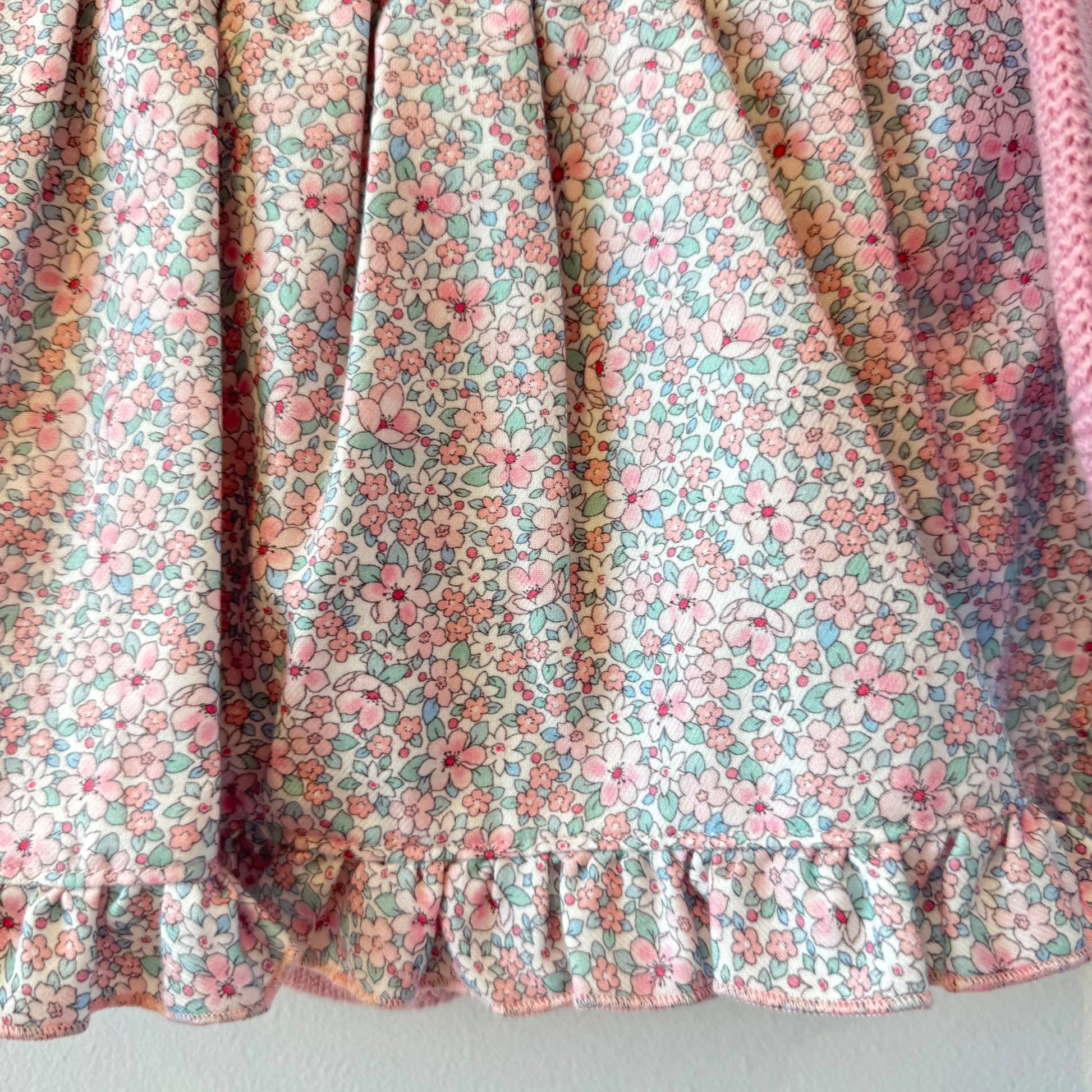 Abitino bimba rosa con culotte coordinata, corpetto in maglia e gonna floreale elegante.