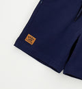Completo bambino casual chic con t-shirt bianca in cotone e bermuda blu.