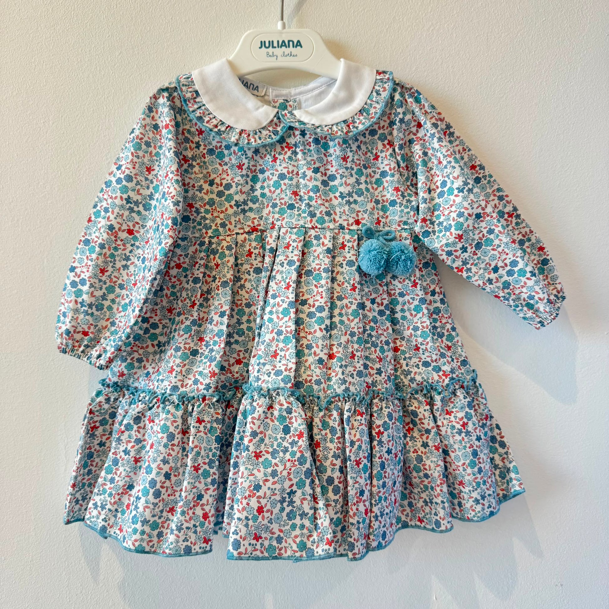 Abitino bimba floreale 100% cotone con colletto bianco e pon pon azzurri.
