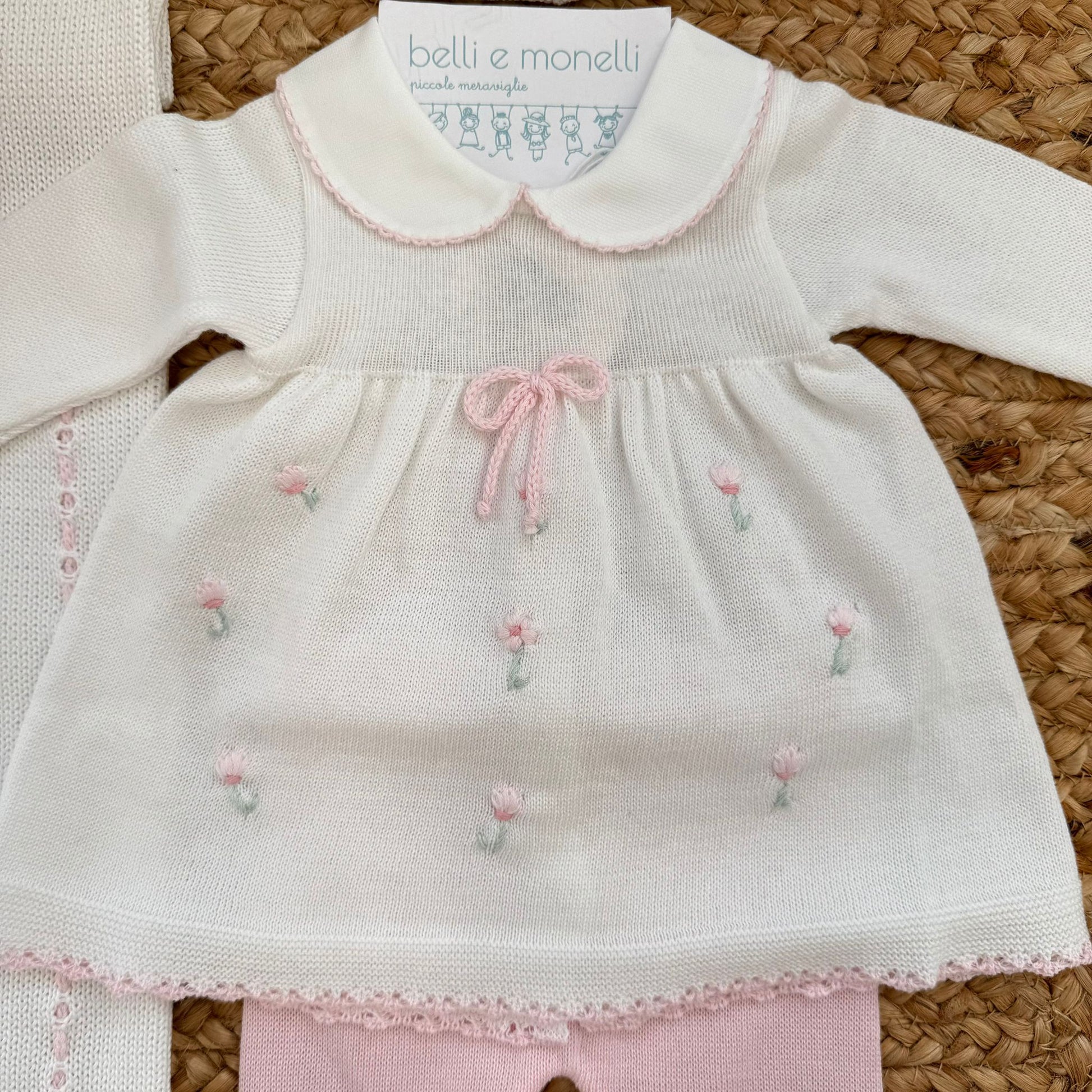 Dettaglio abitino neonata in cotone con ricami floreali e laccetto regolabile