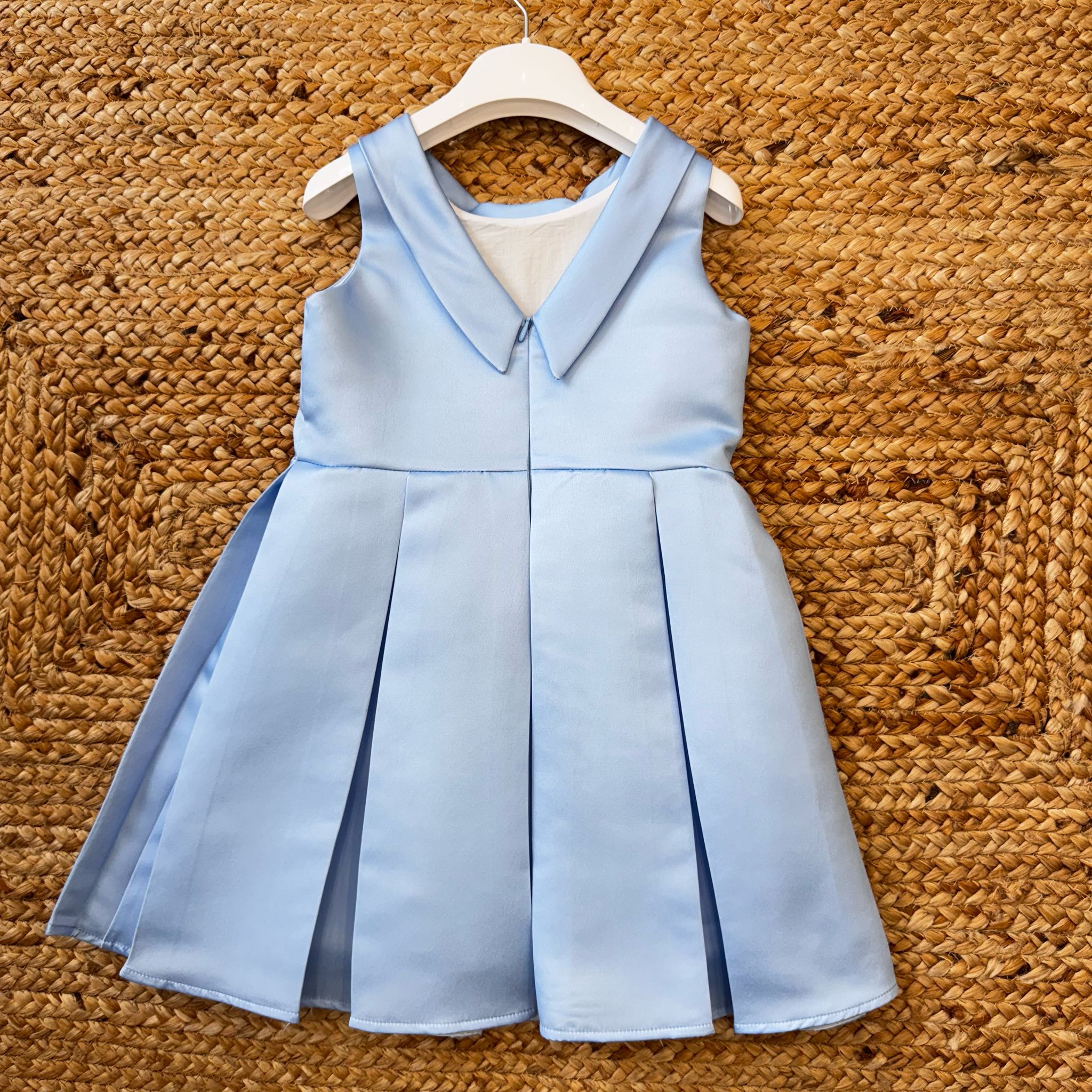 Abito elegante azzurro con fiore laterale e gonna a pieghe