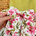 Vestito bambina elegante con corpetto verde pistacchio e gonna floreale rosa con fiocco in vita.