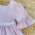 Vestito bambina elegante rosa cipria con pizzo in vita e balze morbide.