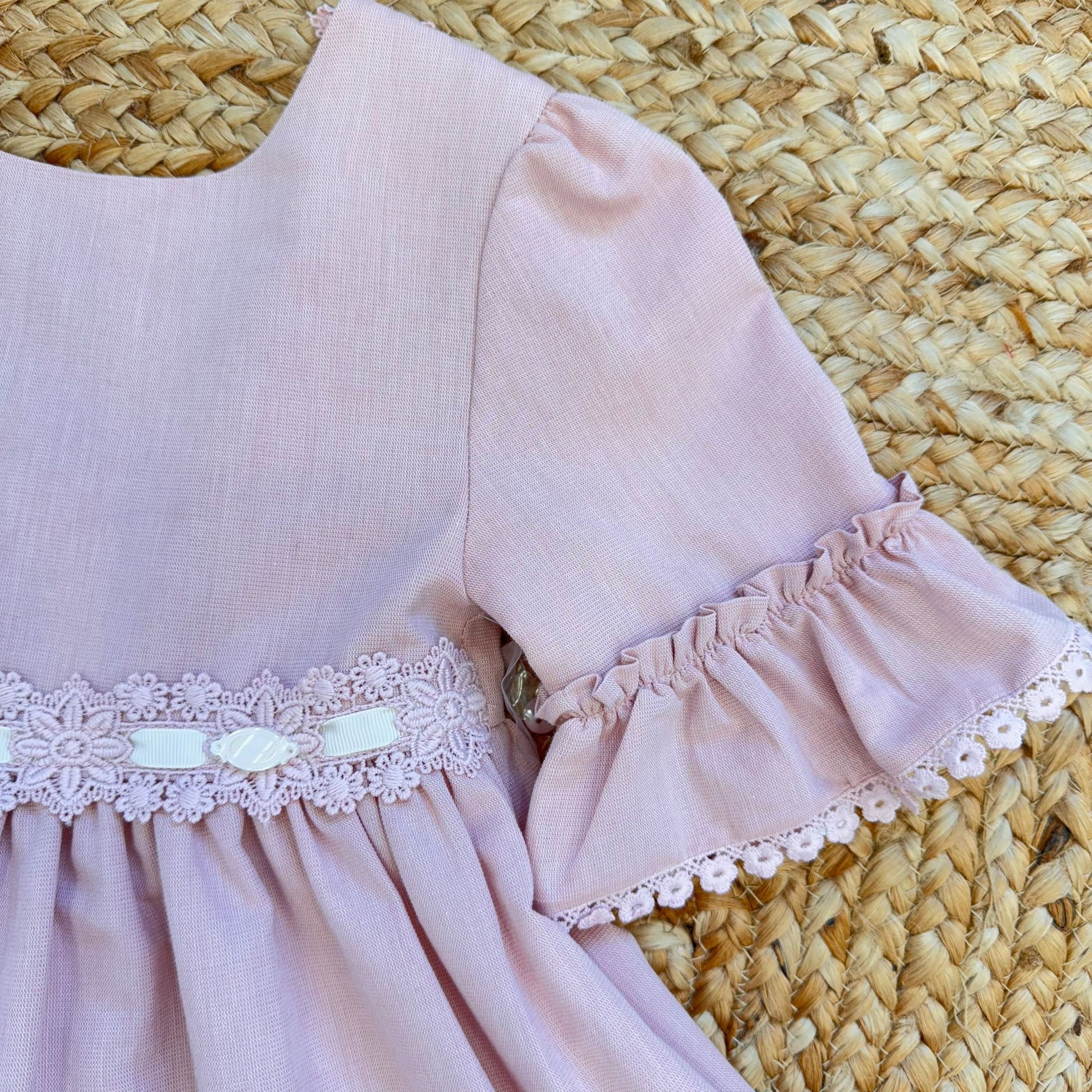 Vestito bambina elegante rosa cipria con pizzo in vita e balze morbide.