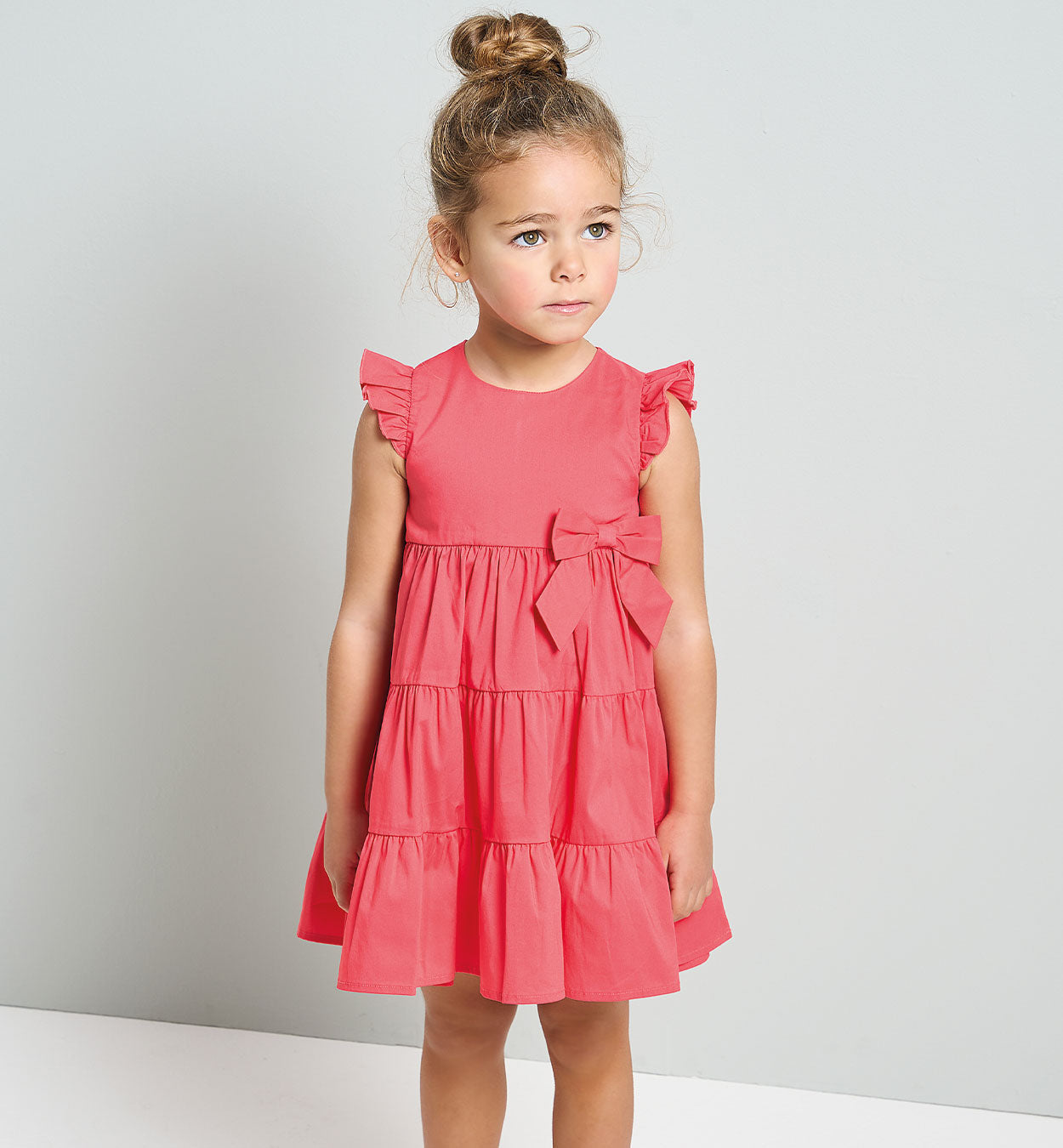 Abito bambina corallo con balze e fiocco laterale