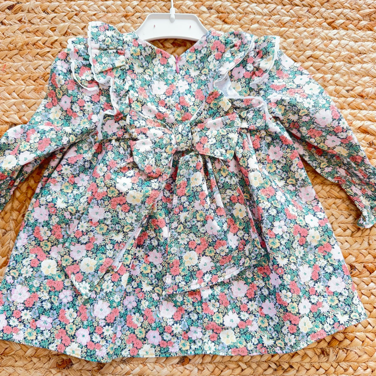 Abito bimba floreale con volant, pompon rosa e fiocco posteriore