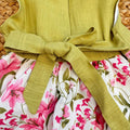Vestito bambina elegante con corpetto verde pistacchio e gonna floreale rosa con fiocco in vita.