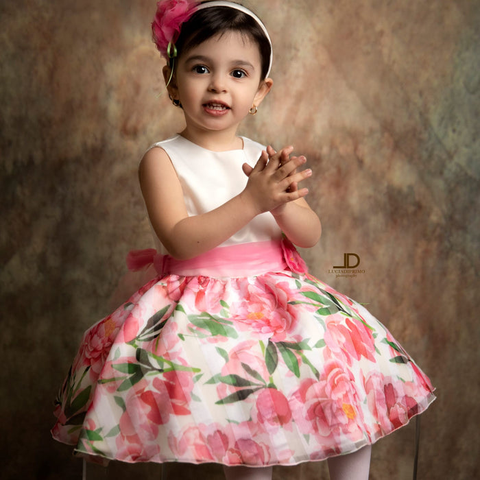 Bambina con abito floreale rosa e cintura in organza per cerimonia