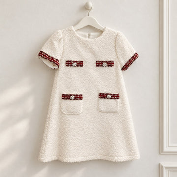 Dettaglio abito elegante bambina panna bouclé con passamaneria bordeaux e decorazioni di perline