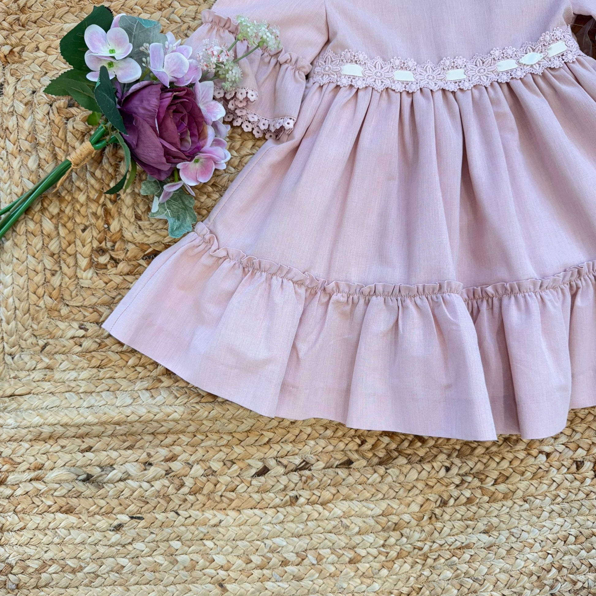 Vestito bambina elegante rosa cipria con pizzo in vita e balze morbide.