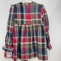 Abito bambina in fantasia tartan scozzese rosso, verde e blu, con maniche lunghe a volant, corpetto arricciato, passamaneria verde e fiocchi frontali.