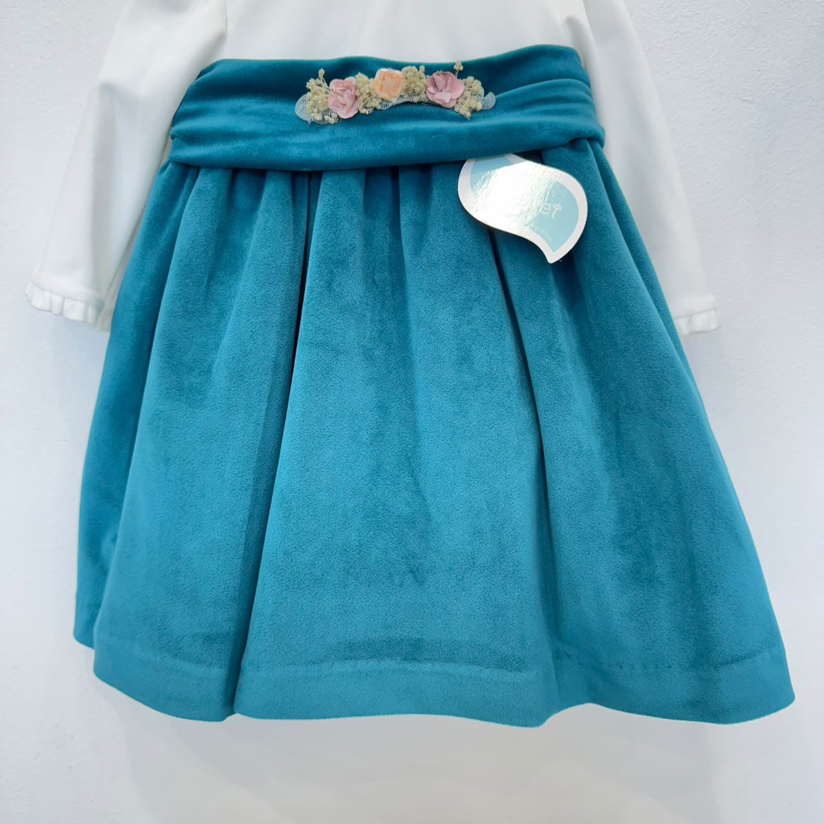 Dettaglio abito elegante bimba in velluto ottanio con corpetto panna e fiori rosa