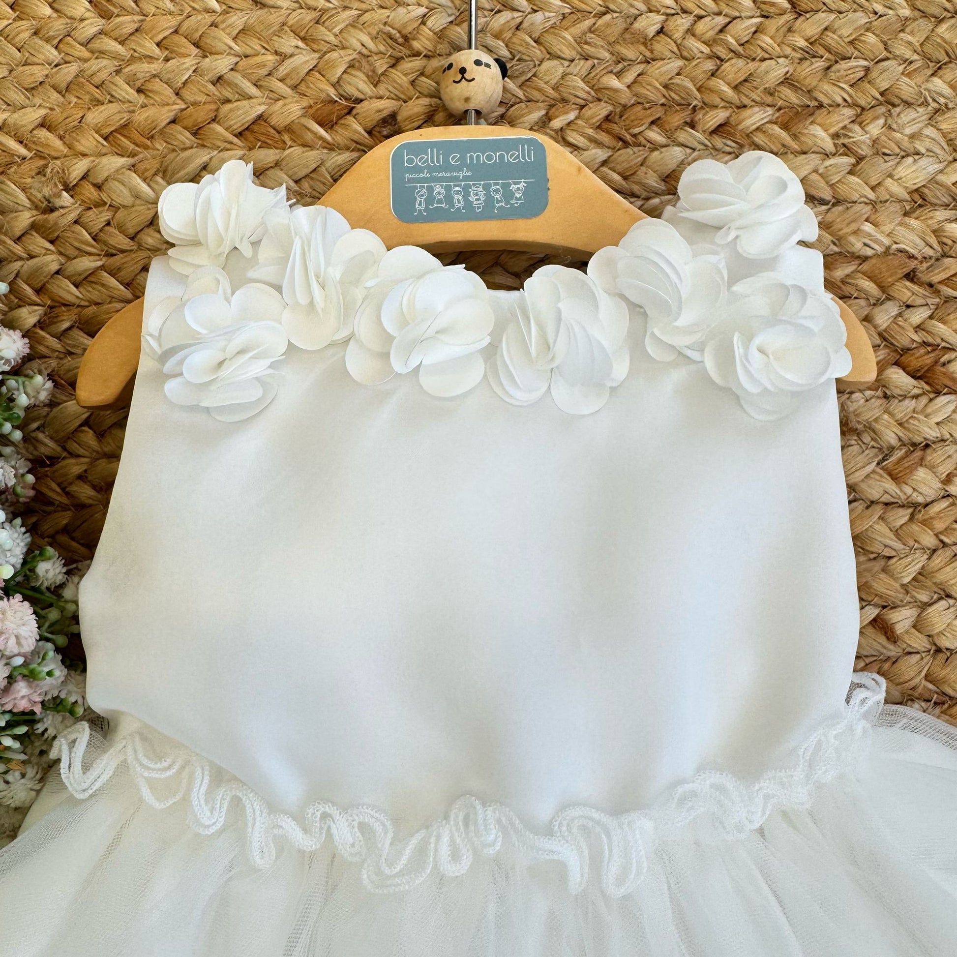 Dettaglio floreale in organza sull’abito battesimale PURE.