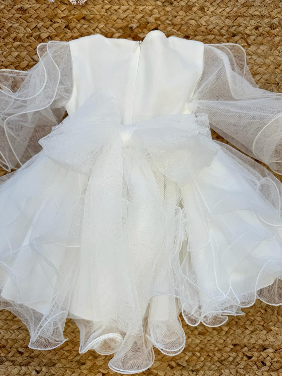 Dettaglio maniche in tulle trasparente su abito da battesimo bambina – Stile romantico